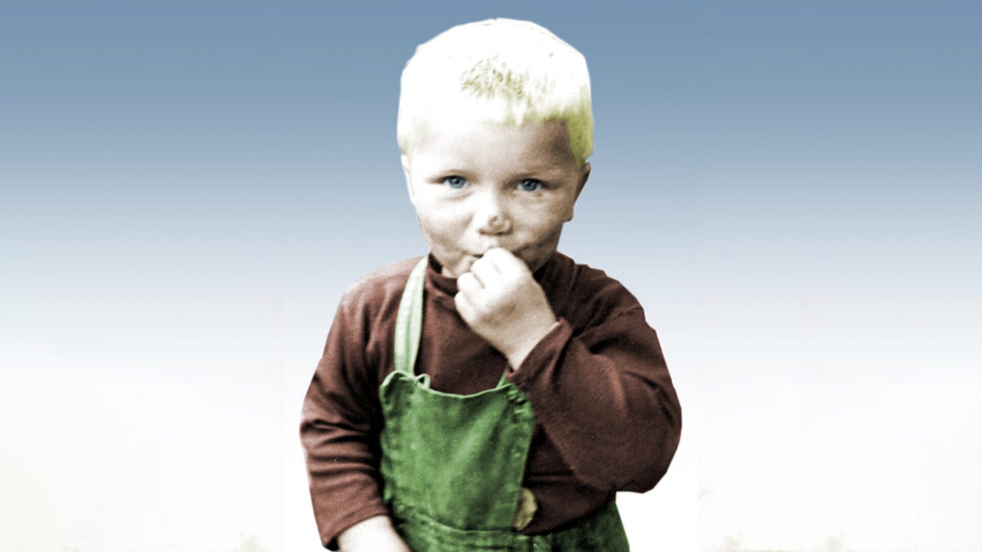 Barndomsbilde av Åge som liten gutt, iført grønn selebukse og mørk genser.