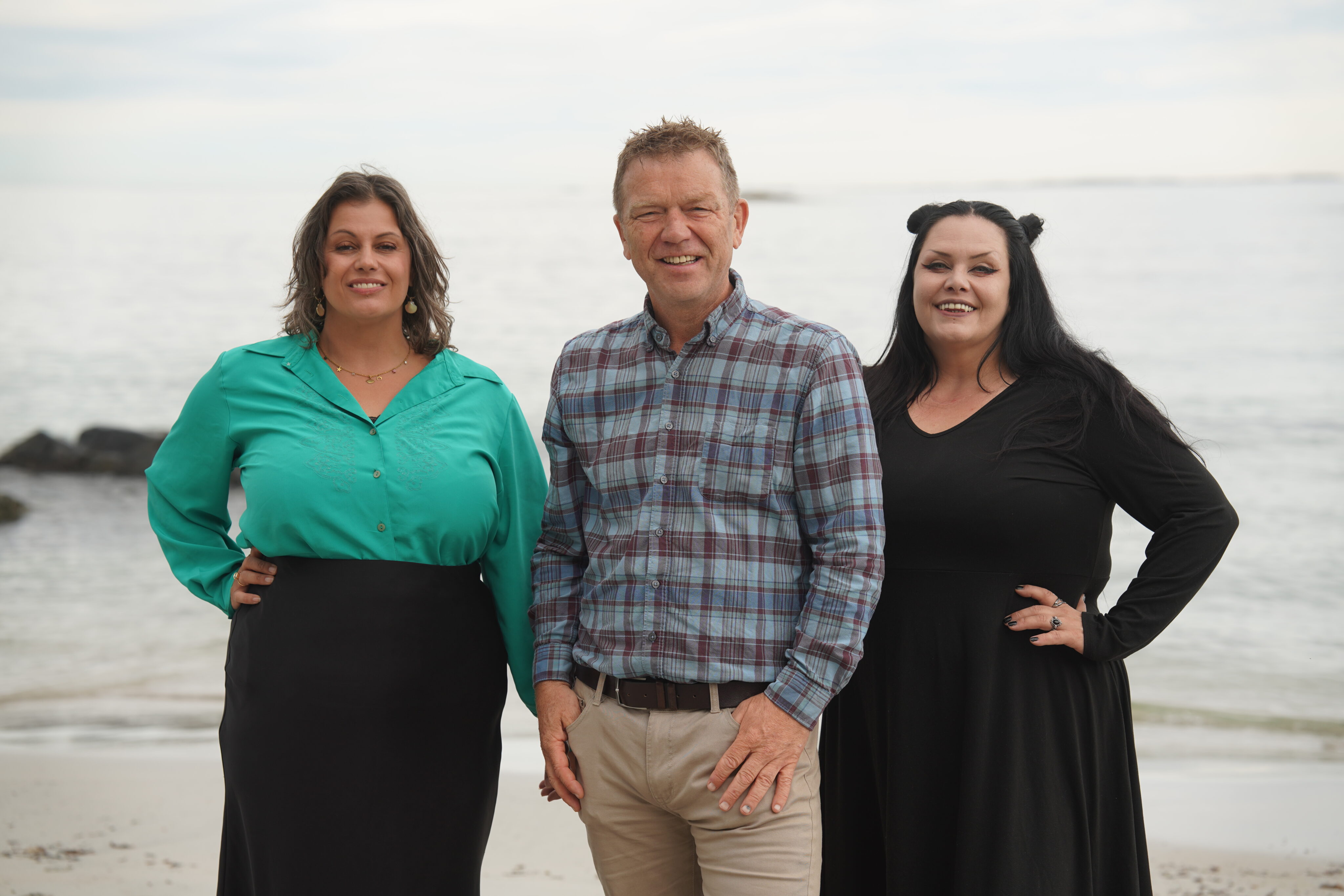 Åge Grimstad, Lena Cavaliere og Stine Johnsen står sammen på en strand
