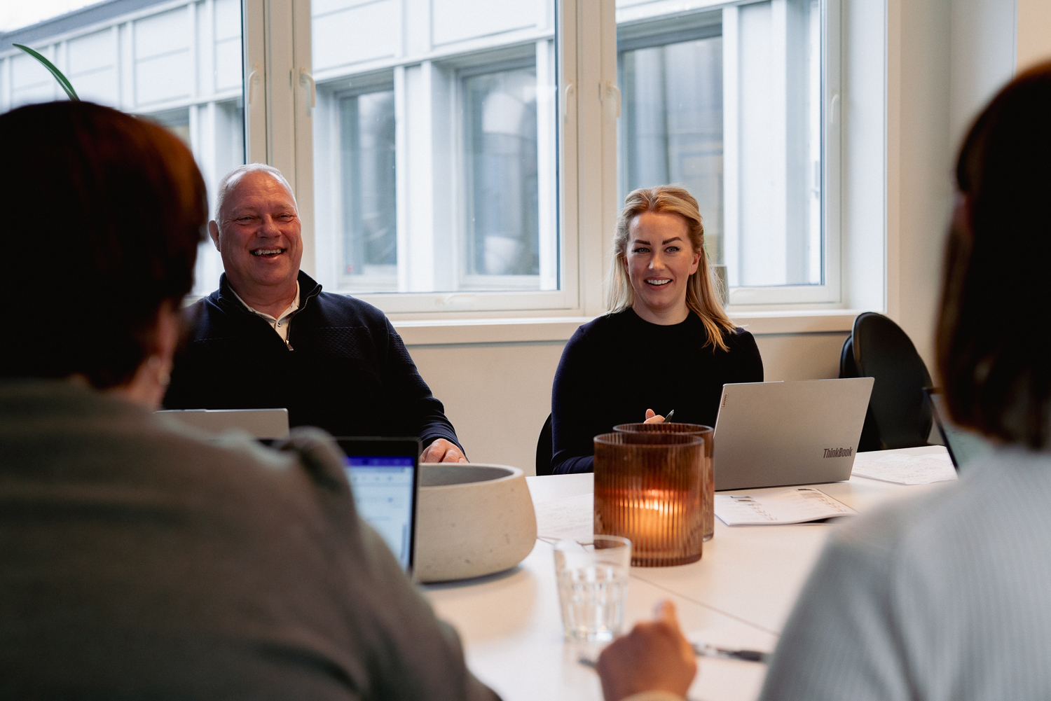 Ansatte i Arena Service Team ler sammen under et møte