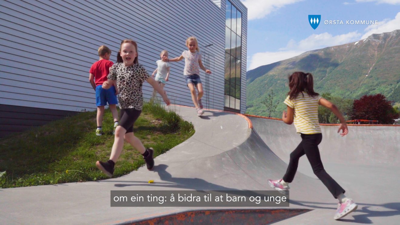Barn som leker ved en skatepark med fjellene i Ørsta i bakgrunnen.