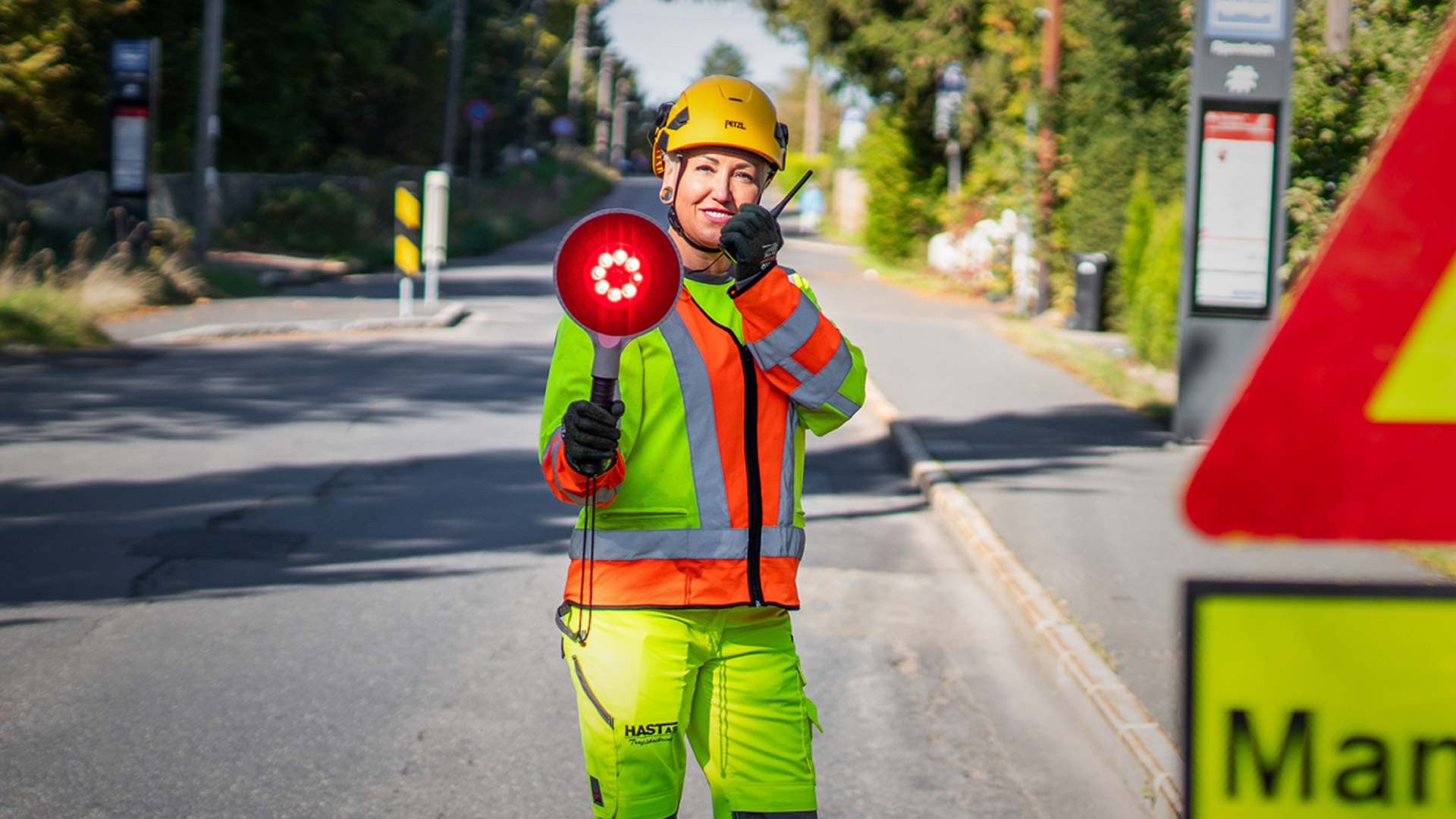Trafikkdirigent fra Hast AS dirigerer trafikken med lyssignal og samband
