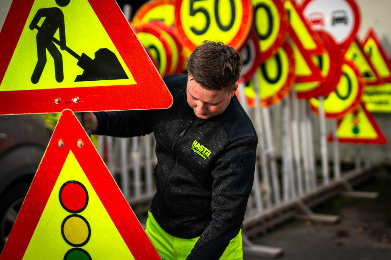 Ansatt i Hast AS håndterer trafikkskilt og sikringsutstyr