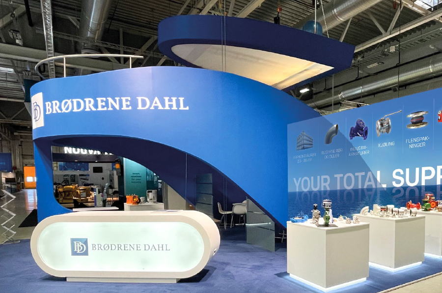 Blå messestand formet som et skip med hvit Brødrene Dahl logo langs siden