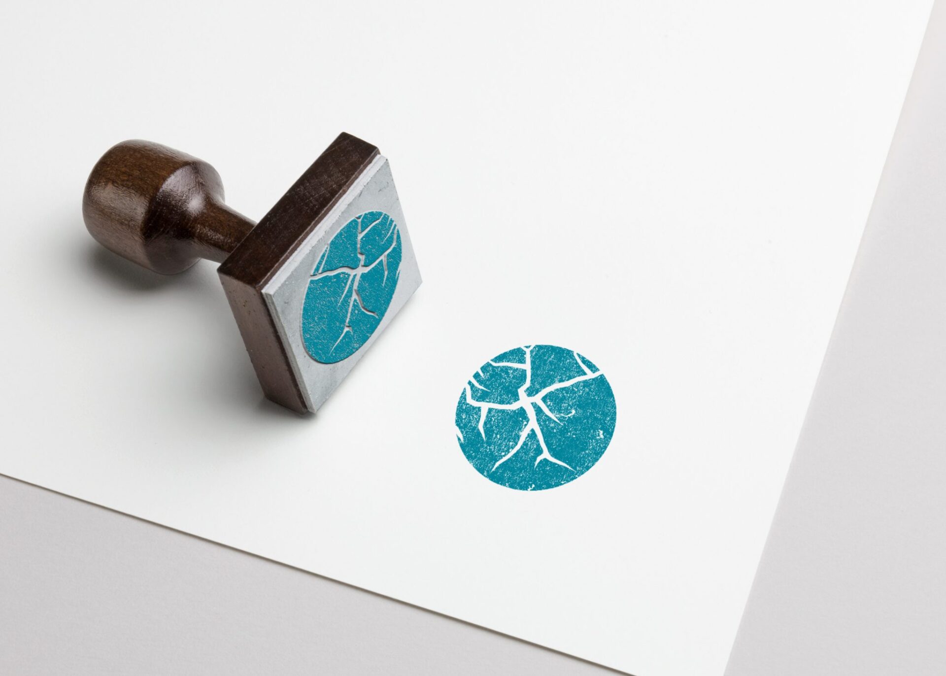 Stempel med Søre Sunnmøre IKTs fjordsymbol og et turkis stempelavtrykk på hvitt papir.